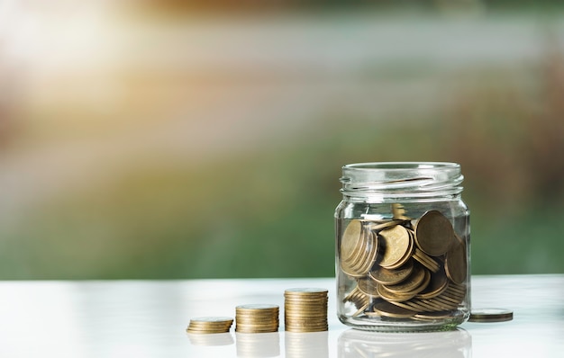 Money coin stacks and glass jar with coins