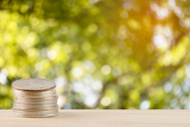 money coins pile with abstract nature bokeh blur background.