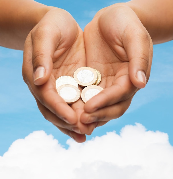 money and finances concept - close up of womans cupped hands showing euro coins