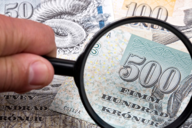 Money from the Faroe Islands in a magnifying glass a business background