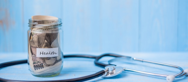 Photo money glass jar and cardiology stethoscope