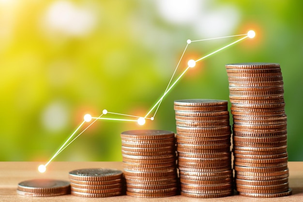 Money saving and finance concept Money saving stack on a wooden table on green background for the investment retirement education and future with graph shows the growing financial condition