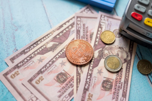 Money and savings coins with dollar bills and a payment terminal for cashless payments