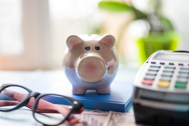 Money and savings coins with dollar bills and a payment terminal