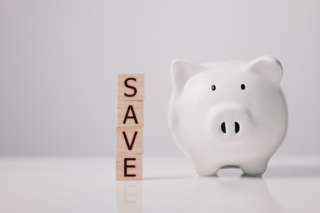 Money savings, save and investment concept. Save from wood cubes and piggy bank.