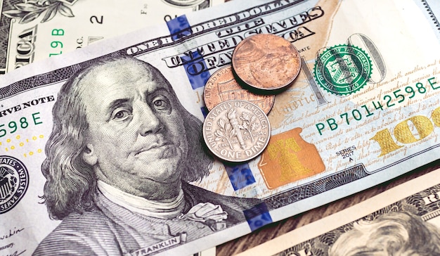 money us dollar dollar banknotes and coins on a wooden table closeup photo and above view