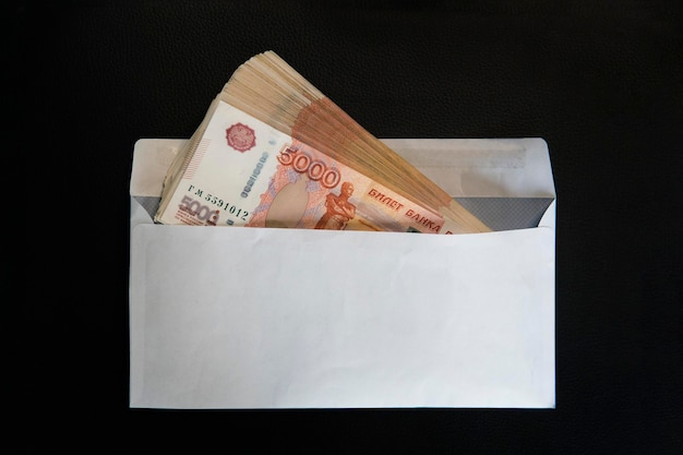 Money in white paper envelope Ruble bribe in an envelope on black background