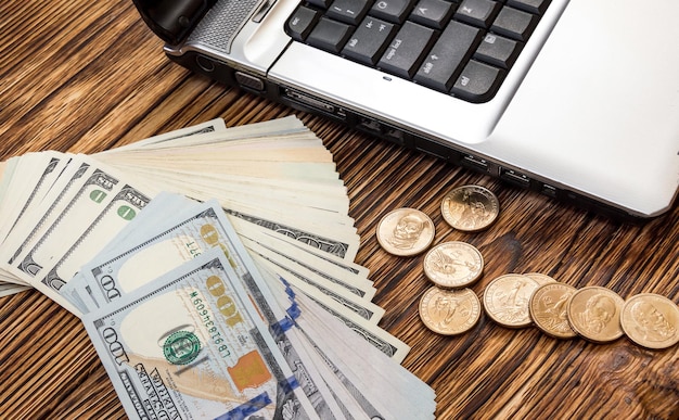 Money with laptop on the wooden table