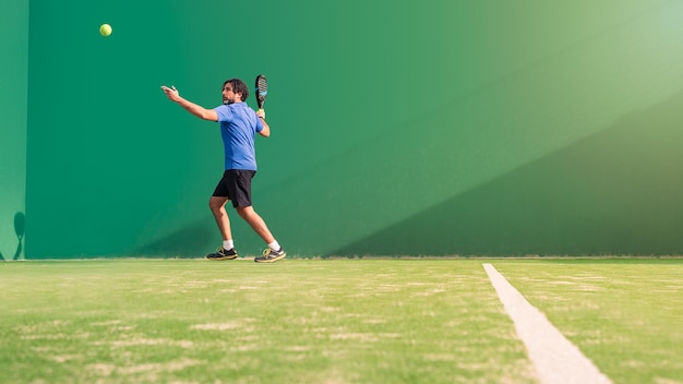 Monitor practicing paddle sport on the outdoor court Man teaching padel class