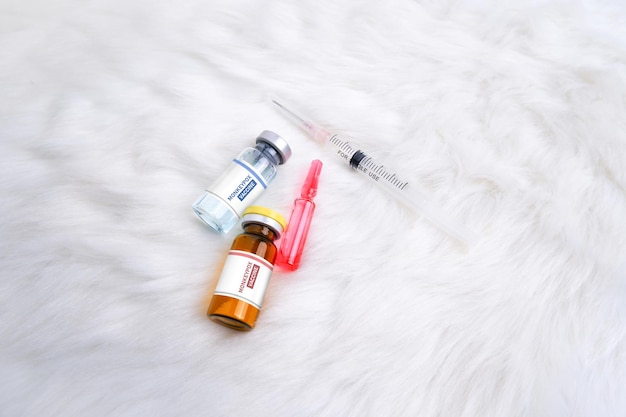 Monkeypox and smallpox virus vaccine bottle MPXV medicine ampoule and syringe on rug background