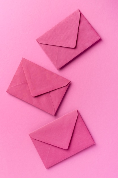 Monochromatic still life assortment with pink envelopes