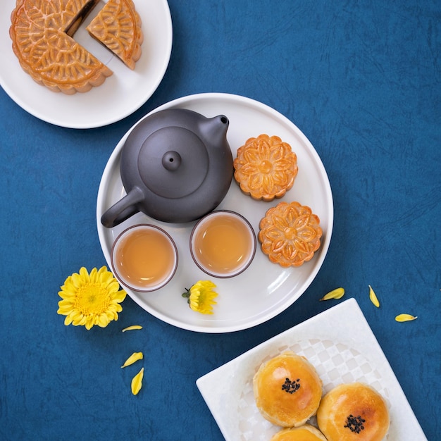 Moon cake for MidAutumn Festival delicious beautiful fresh mooncake on a plate over blue background table top view flat lay layout design concept