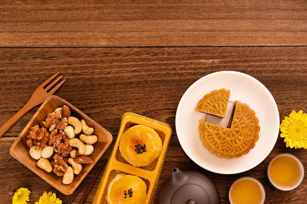 Moon cake for MidAutumn Festival delicious beautiful fresh mooncake on a plate over dark wooden background table top view flat lay layout design concept