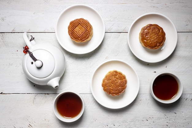 Moon cake Mooncake table setting - Round shaped Chinese traditional pastry with tea cups on table.