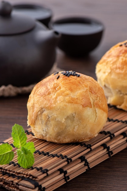 Moon cake yolk pastry mooncake for MidAutumn Festival holiday close up design concept on dark wooden table background