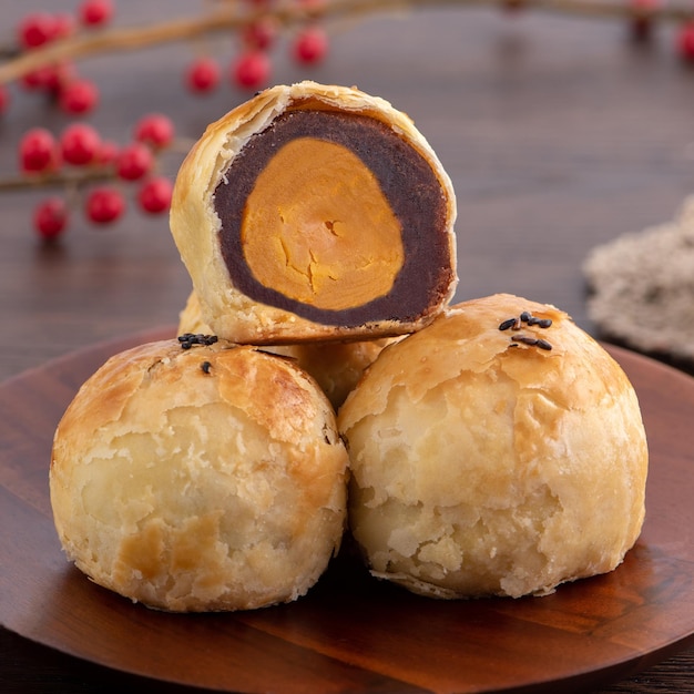 Moon cake yolk pastry mooncake for MidAutumn Festival holiday close up design concept on dark wooden table background