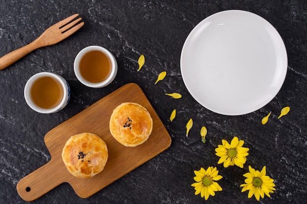 Moon cake yolk pastry mooncake for MidAutumn Festival holiday top view design concept on dark wooden table with copy space flat lay overhead shot