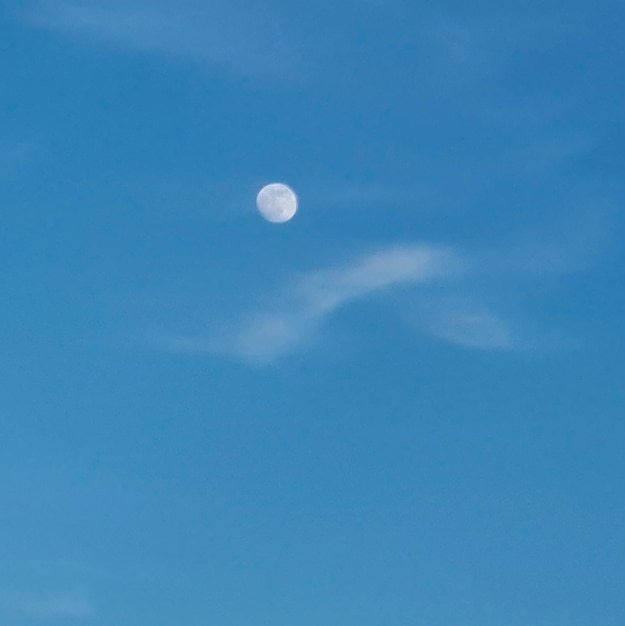 A moon is in the sky with clouds in the sky.