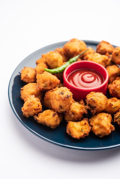 Moong Dal Vada or mungode Pakoda, Dalwada, Pakora or Mungdal Bhajiya or Yellow Split Gram Fritters Served with tomato ketchup