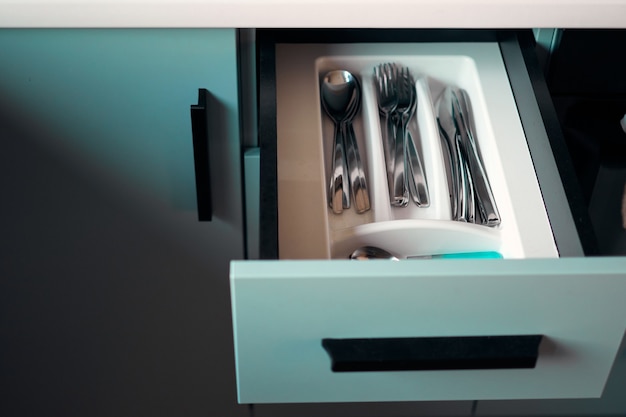 Photo morden kitchen opened drawer full of kitchenware. minimalist interior design. stylish back brick wall in a designer minimalist room interior of an architect. scandinavian style.