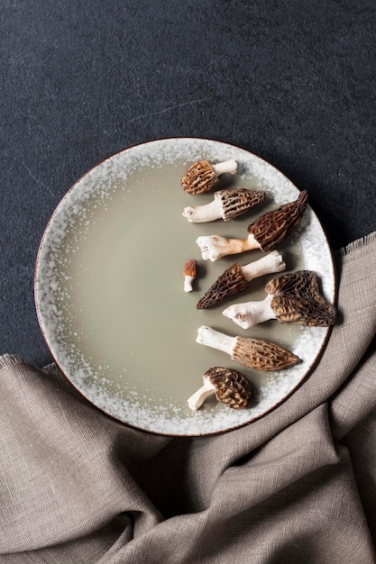 Morel mushrooms on a plate on black background