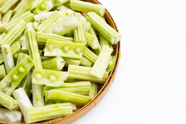 Moringa oleifera cut in pieces in bamboo weave plate on white background