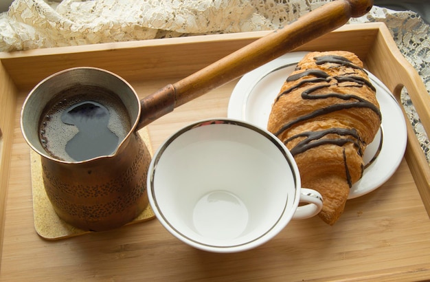 Morning Breakfast in bed a Cup of coffee with croissant on wooden tray