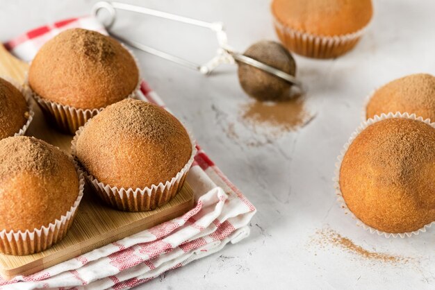 Morning Breakfast Vanilla Muffins in White Paper Cups on Wooden Cutting Board Gray Background