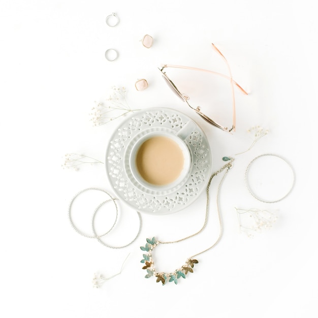 Morning breakfast with cup of coffee with milk and trendy fashion accessories arrangement on white