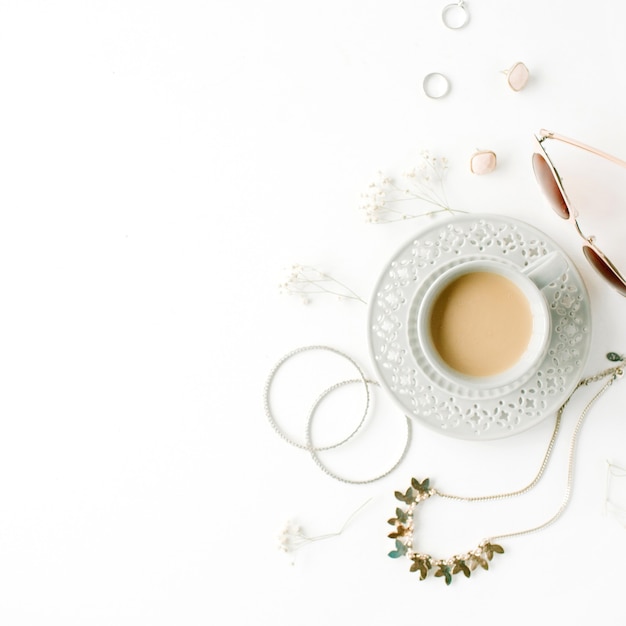 Morning breakfast with cup of coffee with milk and trendy fashion accessories arrangement on white