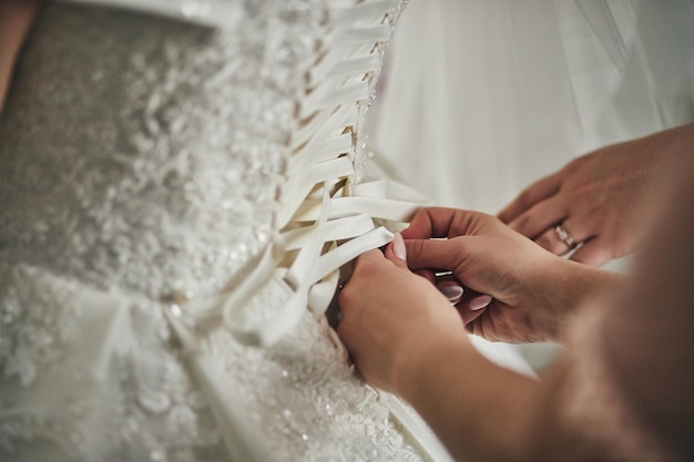 Morning of the bride when she wears a beautiful dress woman getting ready before wedding ceremony