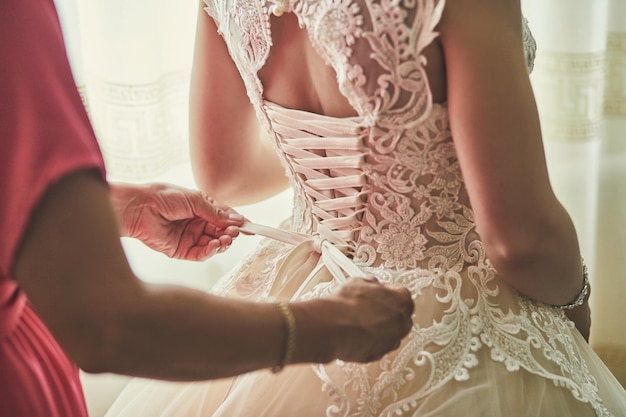 Morning of the bride when she wears a beautiful dress woman getting ready before wedding ceremony