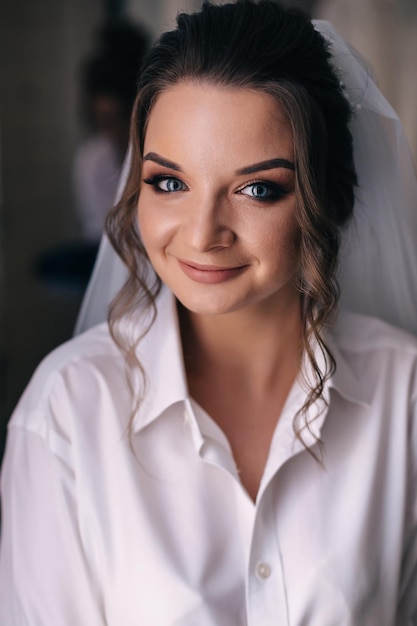 Morning of the bride in a white robe and a veil in the room Wedding preparations