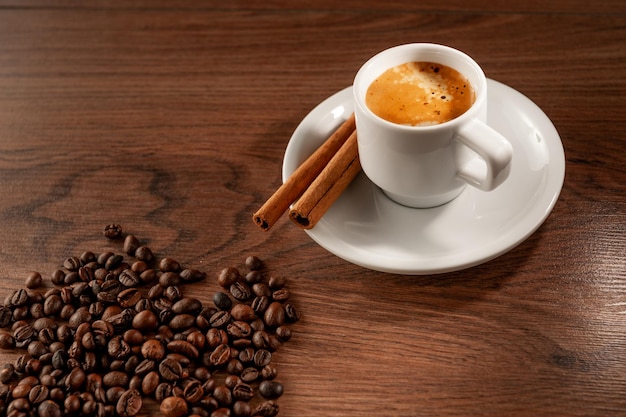 Morning coffee Coffee cup cinnamon and coffee beans on wooden background Top view