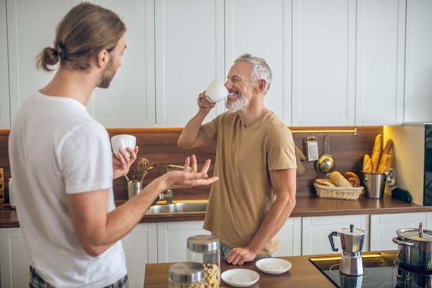 Morning coffee. Couple having coffee together at home and feeling good