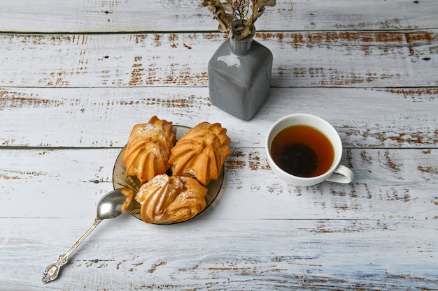 Morning coffee with sweets. with cream filling. flat lay. on a light wooden table.