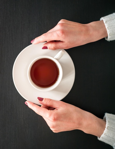 Morning Cup of tea in the hands of a young woman