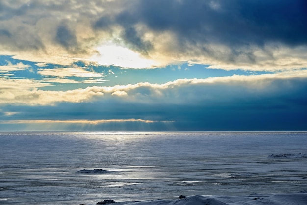 Morning or evening landscape of a large icy lake and cloudy sky with a horizon line