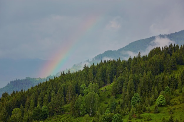 Morning fog with red hot sunrise and rainbow in the mountains