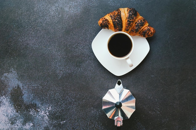 morning. french press coffee, cup of hot coffee and sweet croissant on black background. Top view