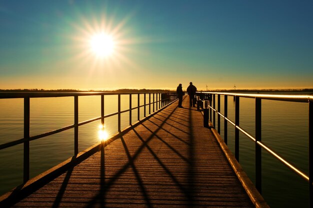 Photo morning in harbor tourists walk on pier above sea sunny clear blue sky smooth water level