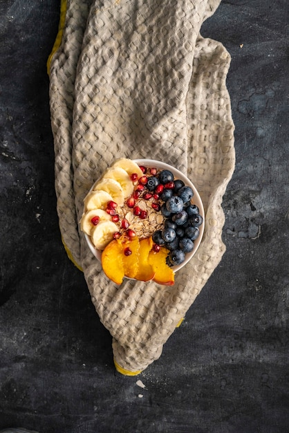 Morning healthy breakfast, cereal with exotic fruits, blueberry, banana, garnet and pears