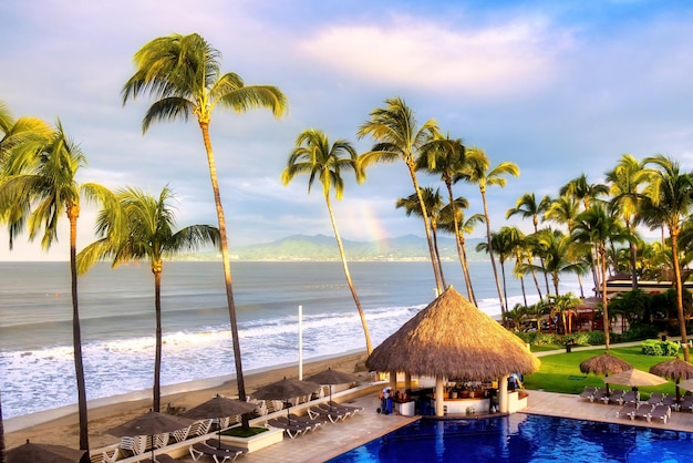 Morning photo of hotel with palm trees and swimming pool on Mexican beaches with copyspace