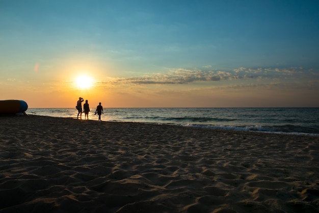 Morning seascape with three people in the backlight.