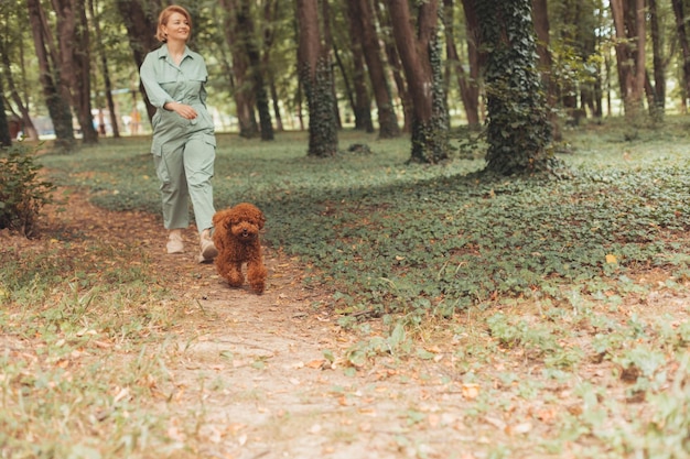 Morning walk in summer park with favourite dog