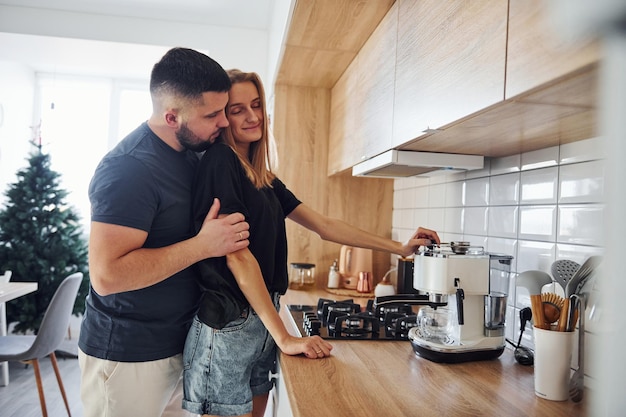 Morning for young married couple that standing indoors in the kitchen.