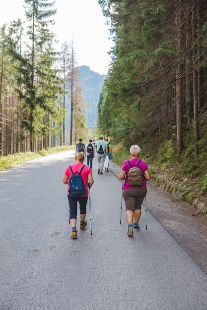 Morske oko Poland September 12 2019 group of people walking by trail seniors with sticks