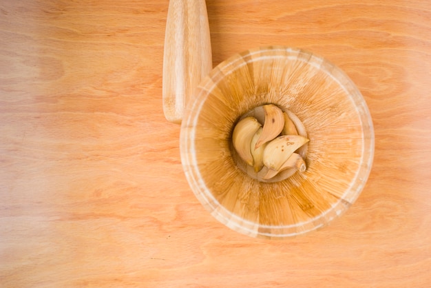 Mortar with dried garlic in horizontal photo on wooden background