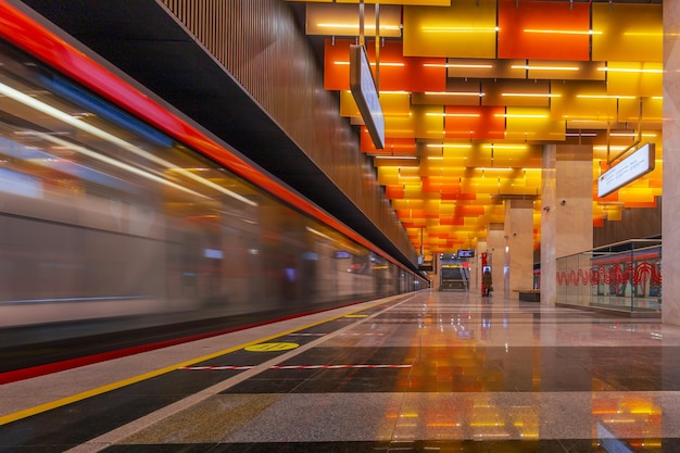 Moscow metro station Novatorskaya with vivid colorful ceiling and blurred moving train