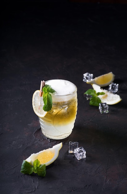 Moscow Mule Cocktail on a dark background Cold drink Layered white and yellow with vodka spicy ginger beer and lime juice Selective focusCocktail card